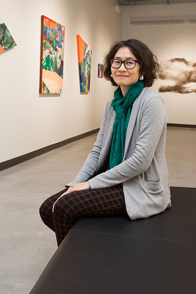 Chun-Fan Chang sitting on bench in art gallery 