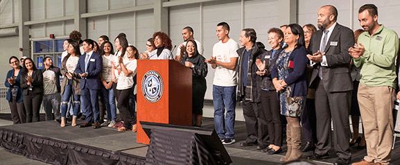 Members of Los Latinos Unidos, faculty and staff join Heather Medina to welcome area high school students to Stockton