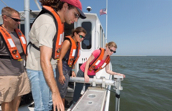 male and women leaning over side of boat 