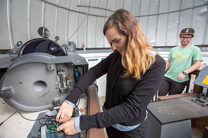 Briena Feltner navigates a maze of color-coded wires on a circuit board that is being refurbished to re-open the Observatory, located off of Pomona Road.