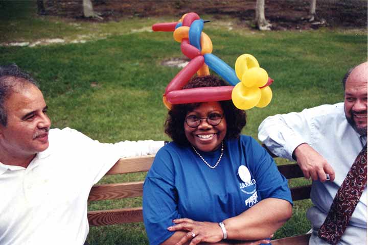 Harvey Kesselman, Vera King Farris with a balloon hat, and Joe Marchetti on a bench