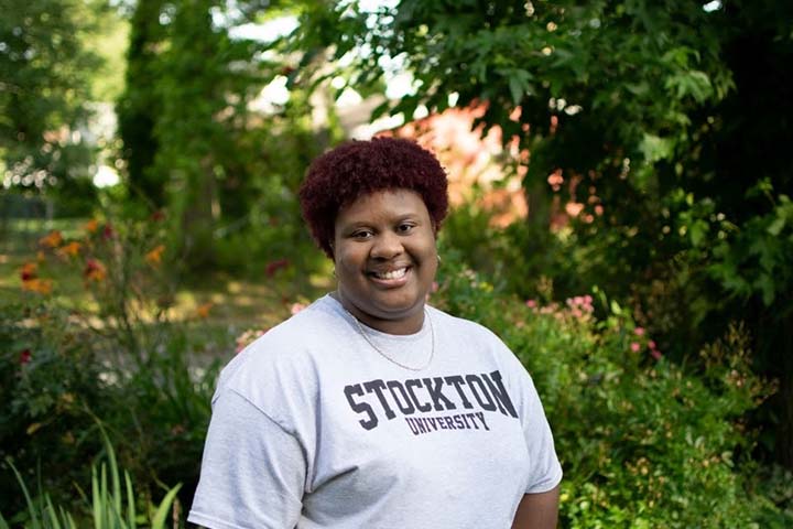 Damaris Spring in a Stockton t-shirt among campus greenery