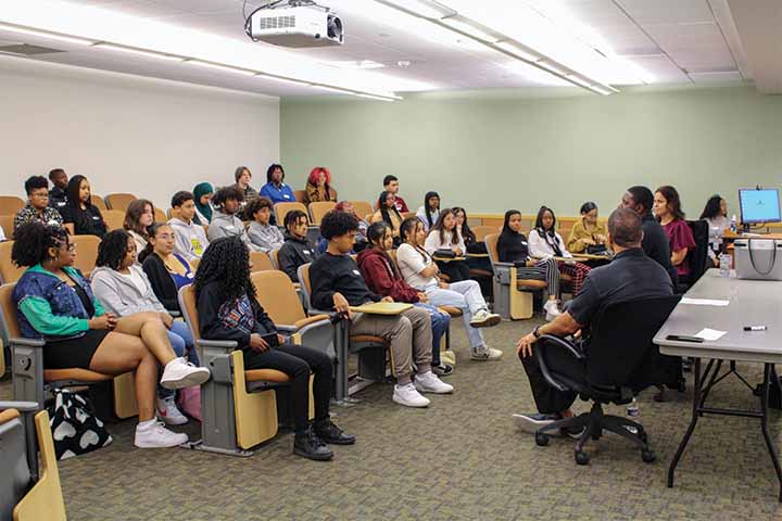 High school students in a college classroom listening intently