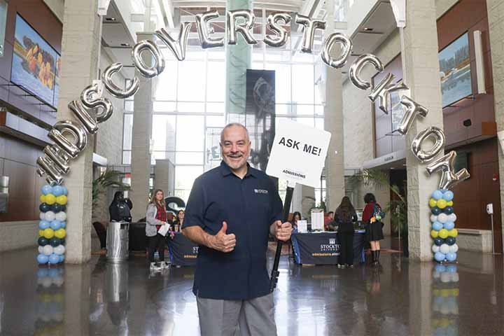 Joe Bertolino holding a sign that says "Ask Me"