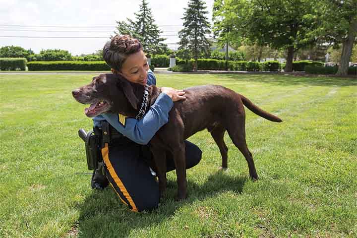 Lt. Tracy Stuart hugging Hemi the chocolate lab