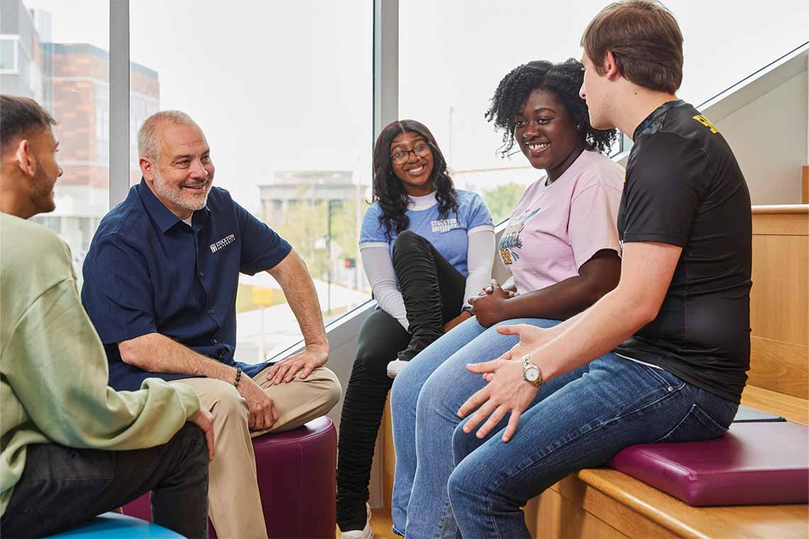 Joe Bertolino sits with students at the Atlantic City residential building