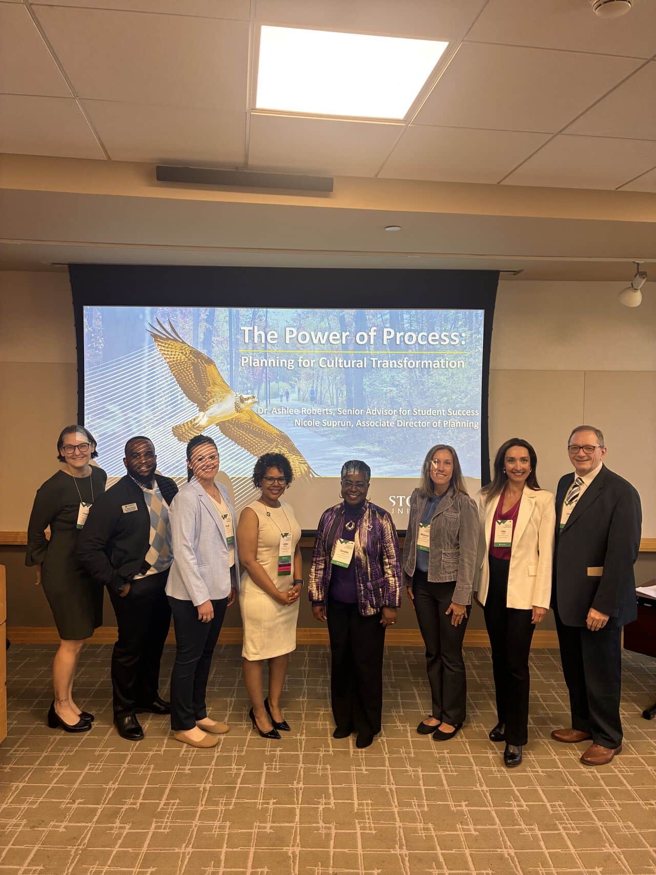 A group of faculty and staff in front of a screen with their presentation
