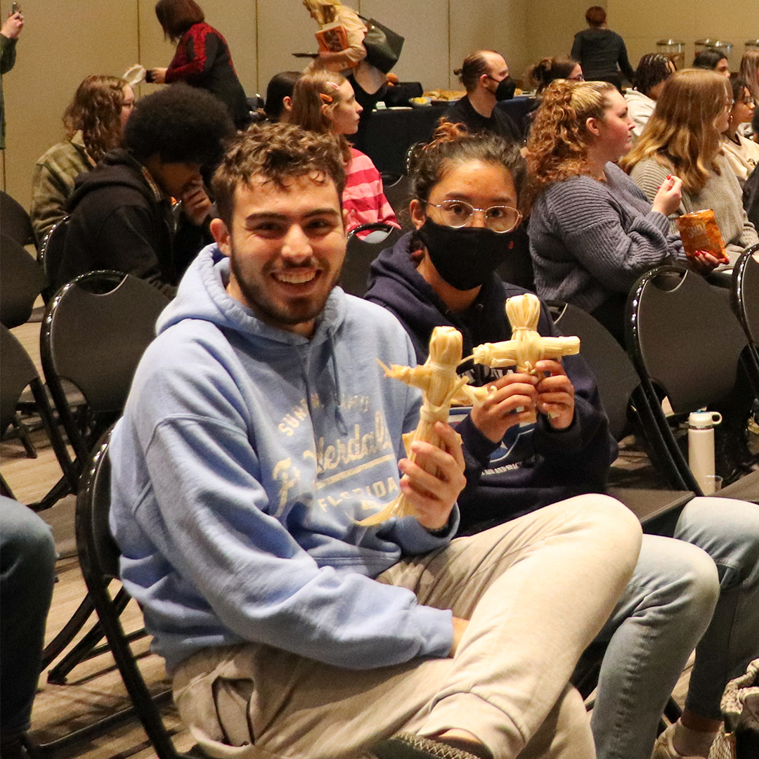 Students holding the corn-husk dolls that River taught them how to make