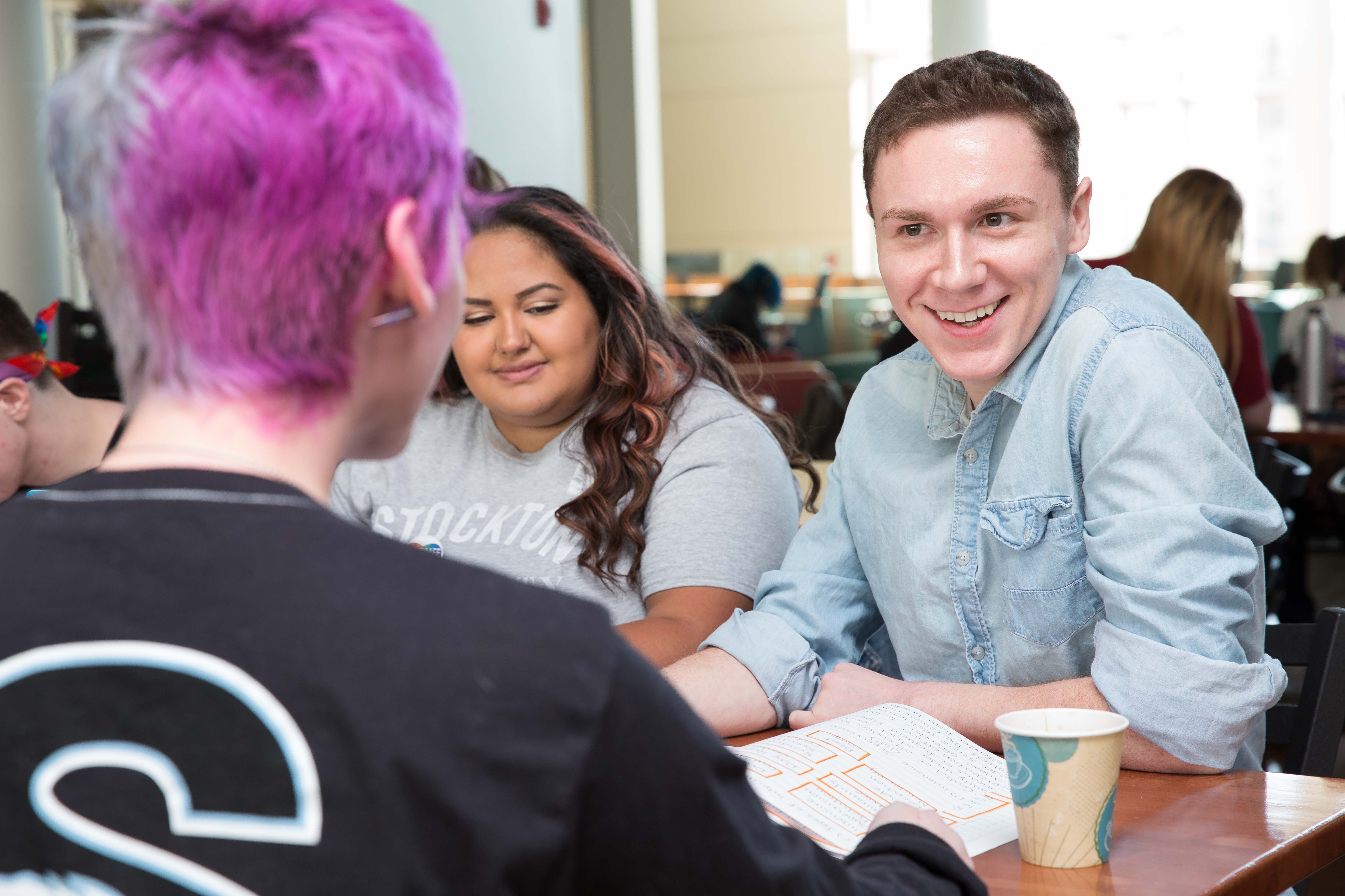 Three students talking at a table